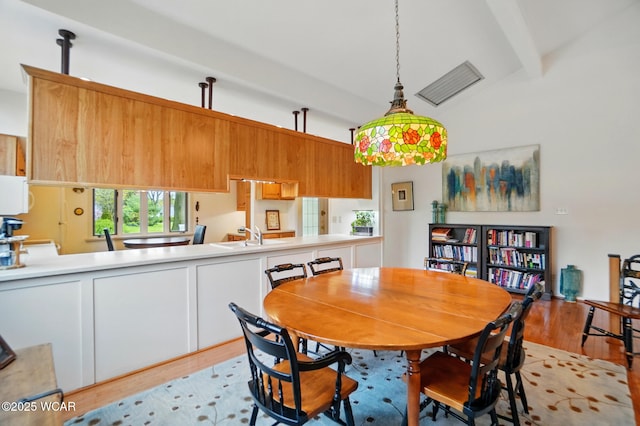 1275 Winterberry Dr, Lima, OH 45805 - dining space featuring light wood-style flooring, beam ceiling, and high vaulted ceiling