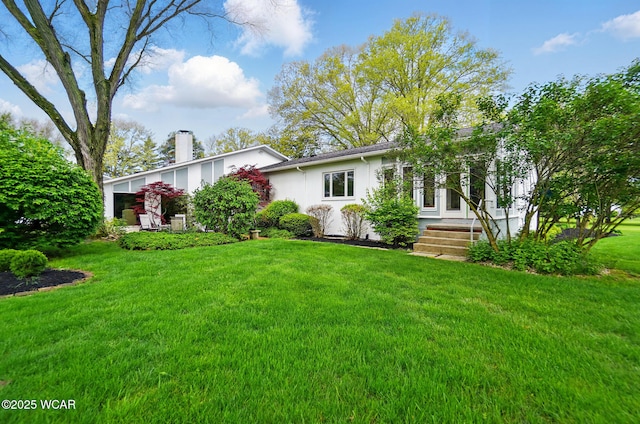 1275 Winterberry Dr, Lima, OH 45805 - view of front facade featuring a front yard, stucco siding, and a chimney