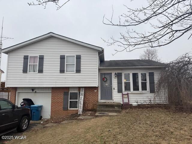 split level home featuring a garage and a front lawn