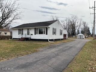 view of front of home featuring a shed and a front yard