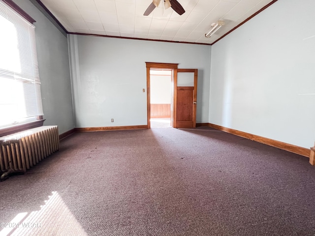 empty room with radiator, carpet floors, ornamental molding, and ceiling fan