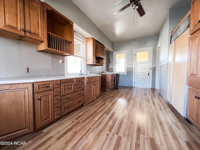 kitchen with sink, ceiling fan, and light hardwood / wood-style flooring