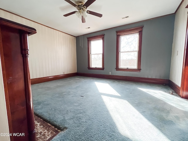 unfurnished room with crown molding, carpet, and ceiling fan