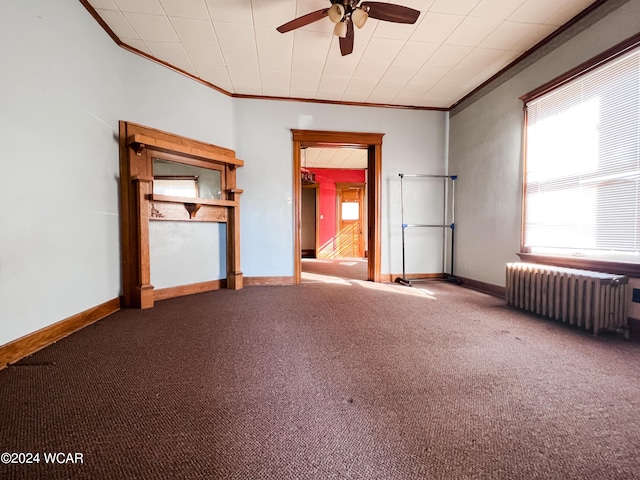 carpeted spare room with crown molding, radiator, and ceiling fan