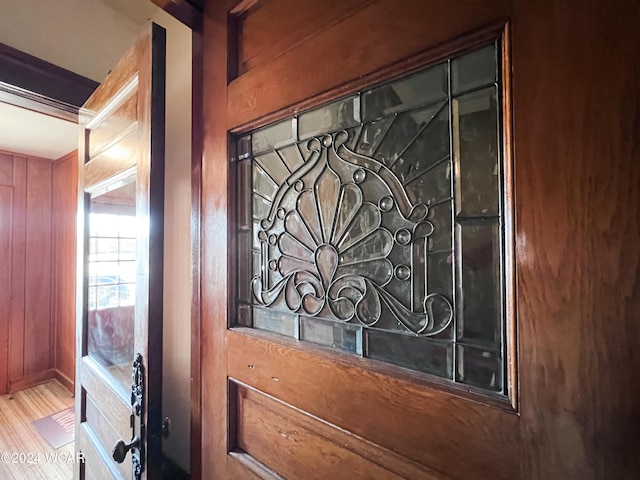 interior details with hardwood / wood-style flooring and wood walls