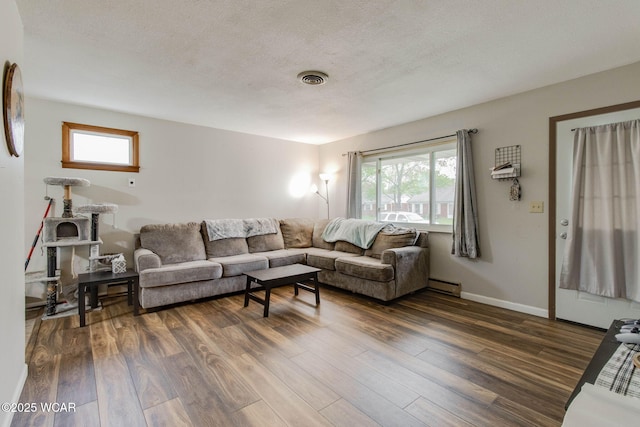 1153 Bahama Dr, Lima, OH 45801 - living room with plenty of natural light, visible vents, dark wood-style flooring, and a baseboard heating unit