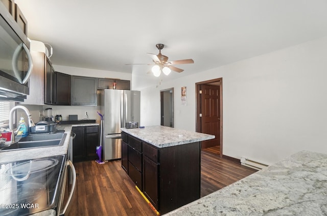 118 S Wagner Ave, Wapakoneta, OH 45895 - kitchen with a center island, a sink, baseboard heating, a ceiling fan, and appliances with stainless steel finishes