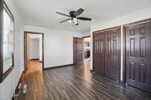 118 S Wagner Ave, Wapakoneta, OH 45895 - unfurnished bedroom featuring baseboards, a ceiling fan, multiple closets, and dark wood-style floors