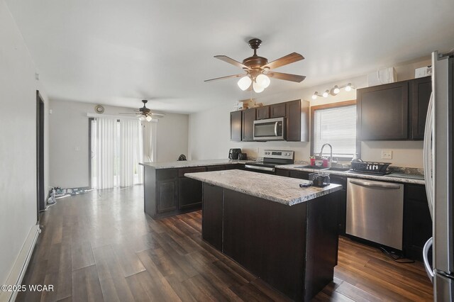 118 S Wagner Ave, Wapakoneta, OH 45895 - kitchen with a peninsula, a sink, dark wood finished floors, a ceiling fan, and appliances with stainless steel finishes