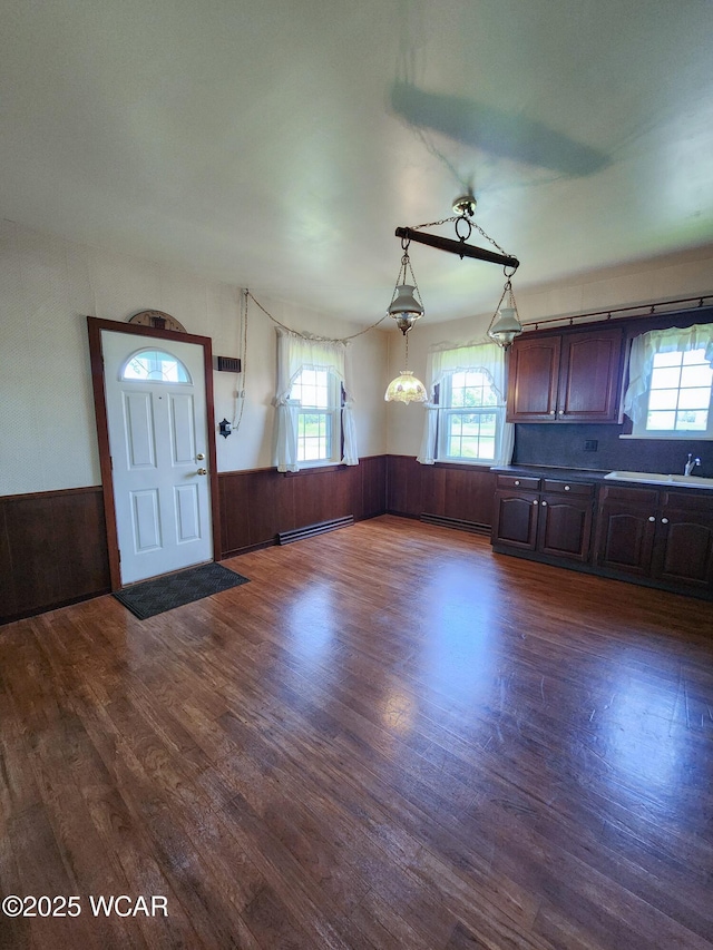 11205 Rd Z, Columbus Grove, OH 45830 - kitchen featuring a baseboard heating unit, a wainscoted wall, dark wood-style floors, dark brown cabinetry, and wood walls