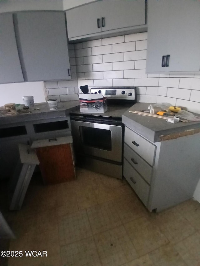 kitchen with electric range and backsplash