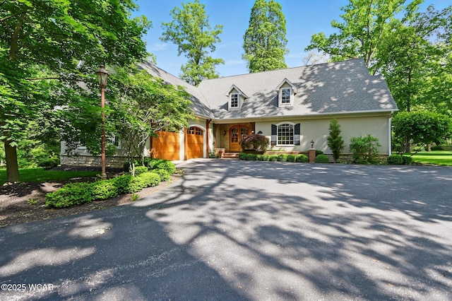 7 Estate Dr, Lima, OH 45805 - cape cod home featuring driveway, an attached garage, and stucco siding
