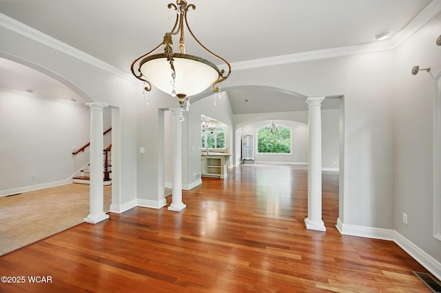 7 Estate Dr, Lima, OH 45805 - unfurnished dining area featuring arched walkways, wood finished floors, stairs, ornamental molding, and baseboards