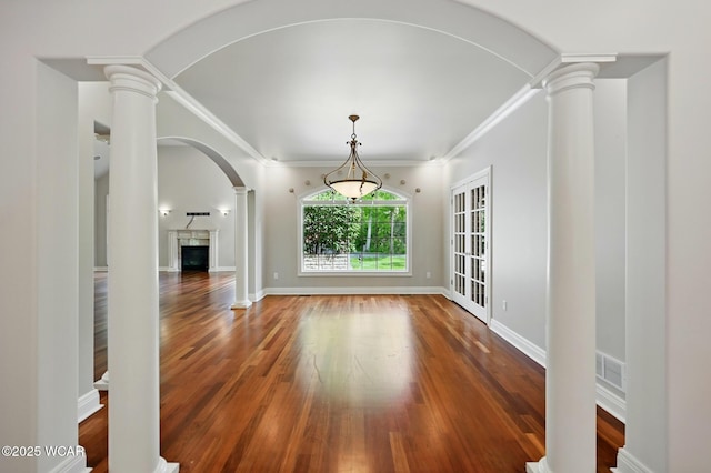 7 Estate Dr, Lima, OH 45805 - unfurnished dining area with decorative columns, arched walkways, wood finished floors, ornamental molding, and a fireplace