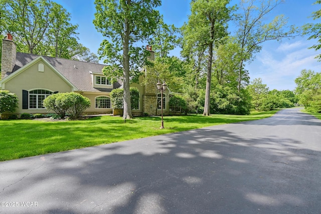 7 Estate Dr, Lima, OH 45805 - view of front of property with a chimney, a front lawn, and stucco siding