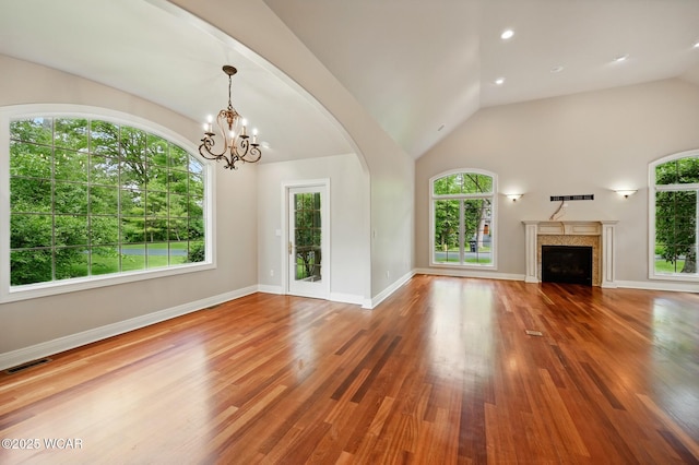 7 Estate Dr, Lima, OH 45805 - unfurnished living room with healthy amount of natural light, lofted ceiling, wood finished floors, a chandelier, and a fireplace