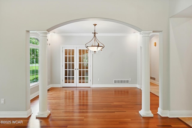 7 Estate Dr, Lima, OH 45805 - unfurnished dining area featuring wood finished floors, french doors, arched walkways, ornamental molding, and baseboards