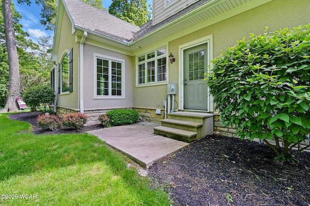 7 Estate Dr, Lima, OH 45805 - doorway to property featuring a shingled roof, stucco siding, and a lawn