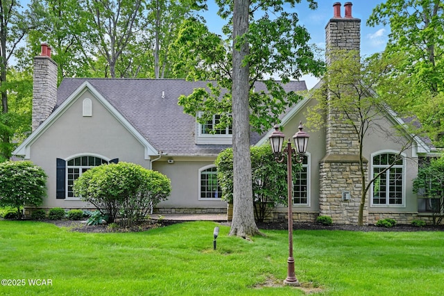 7 Estate Dr, Lima, OH 45805 - view of front of home with a chimney, stucco siding, and a front lawn