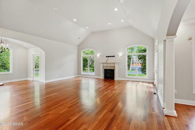 7 Estate Dr, Lima, OH 45805 - unfurnished living room with a fireplace, wood finished floors, baseboards, decorative columns, and high vaulted ceiling