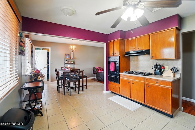 642 Meadowbrook Dr, Lima, OH 45801 - kitchen with black appliances, under cabinet range hood, a warming drawer, brown cabinets, and plenty of natural light