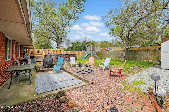 642 Meadowbrook Dr, Lima, OH 45801 - fenced backyard featuring a playground, a fire pit, a shed, a patio, and an outdoor structure