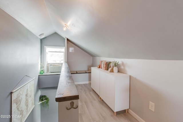 interior space with vaulted ceiling, cooling unit, and light hardwood / wood-style flooring