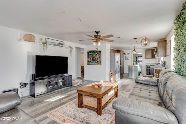 living room with ceiling fan and light hardwood / wood-style flooring