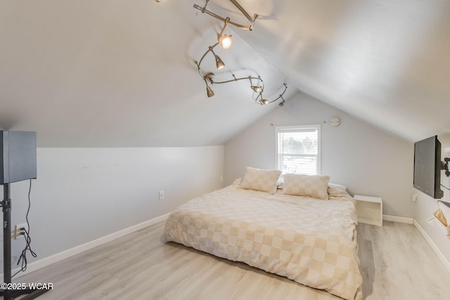 bedroom with lofted ceiling and light hardwood / wood-style flooring