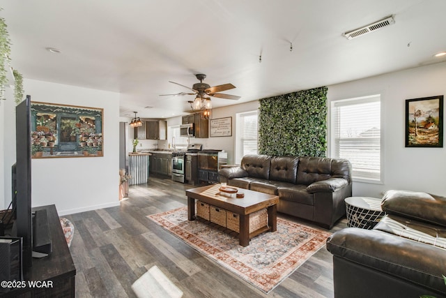 living room with dark wood-type flooring and ceiling fan