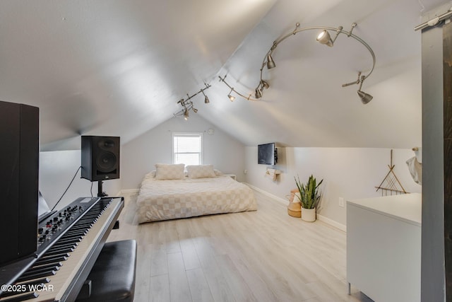 bedroom featuring lofted ceiling and light hardwood / wood-style floors