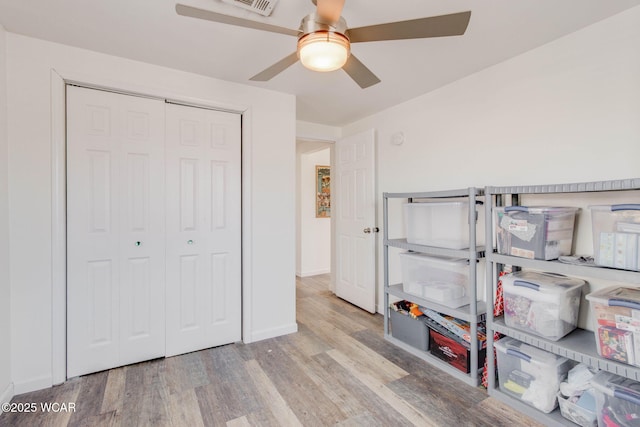 bedroom featuring light wood-type flooring, ceiling fan, and a closet