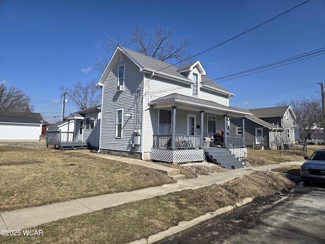 view of front facade with a shingled roof, a front lawn, and a porch