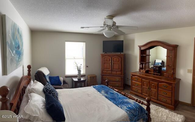 bedroom featuring a ceiling fan, a textured ceiling, and wood finished floors