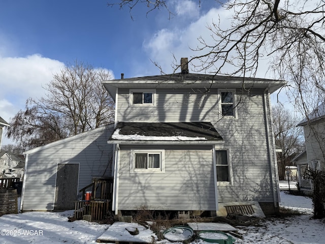 view of snow covered rear of property