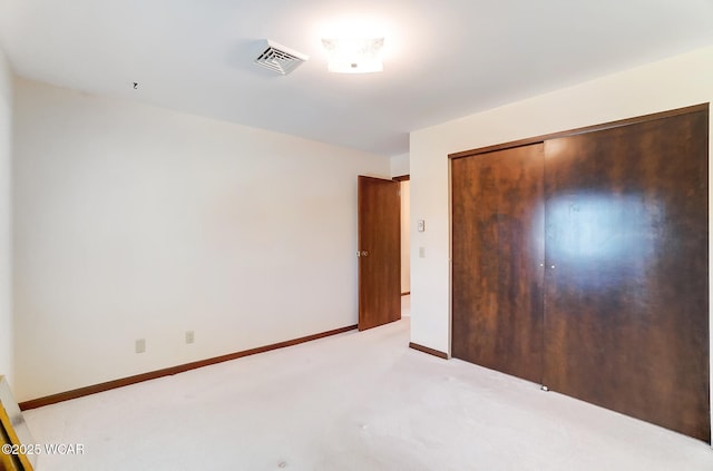 unfurnished bedroom featuring light carpet and a closet