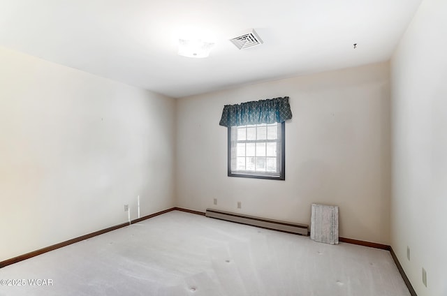 spare room featuring carpet and a baseboard heating unit