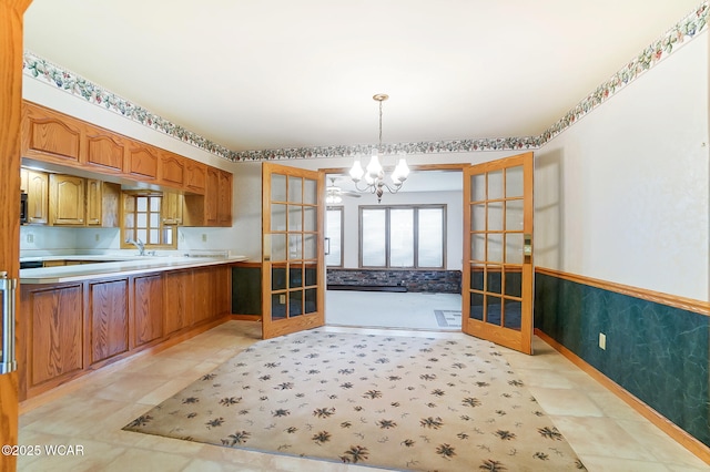 kitchen with french doors, sink, a notable chandelier, and decorative light fixtures