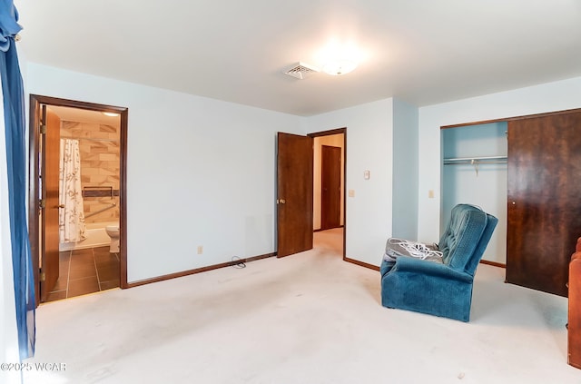 interior space featuring carpet, ensuite bath, and a closet