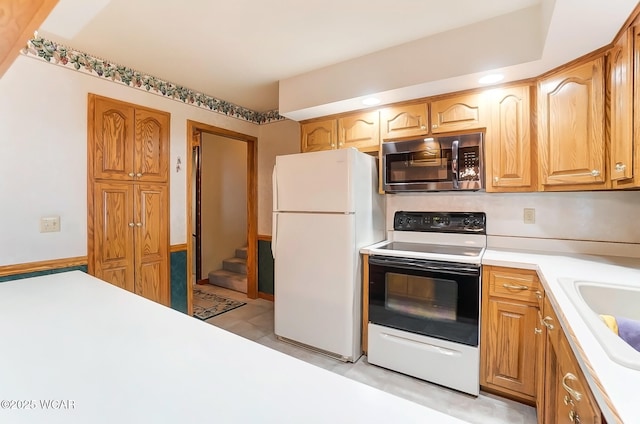 kitchen featuring white fridge, sink, and electric range