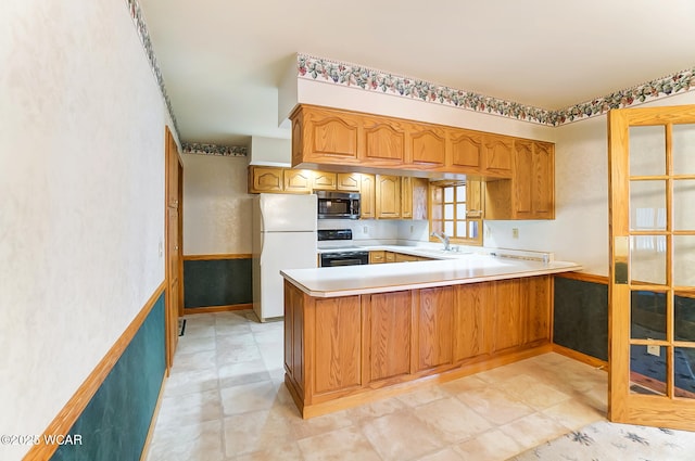 kitchen featuring white refrigerator, stove, sink, and kitchen peninsula