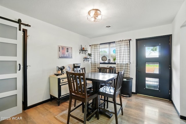 718 Wildwood Ave, Lima, OH 45807 - dining room with light wood finished floors and a barn door