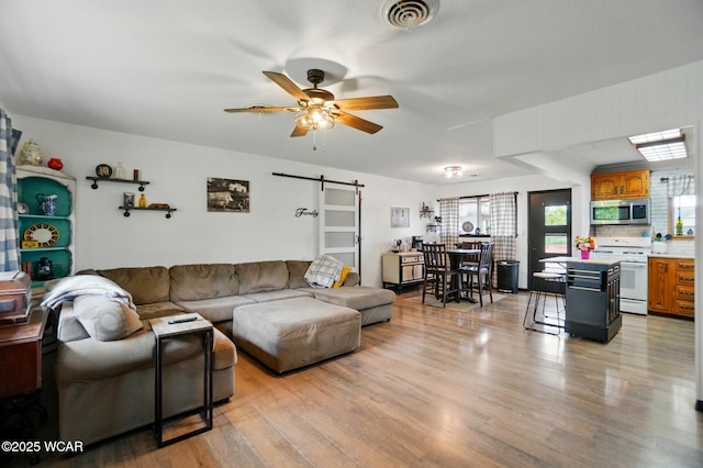718 Wildwood Ave, Lima, OH 45807 - living area with a barn door, light wood finished floors, and ceiling fan