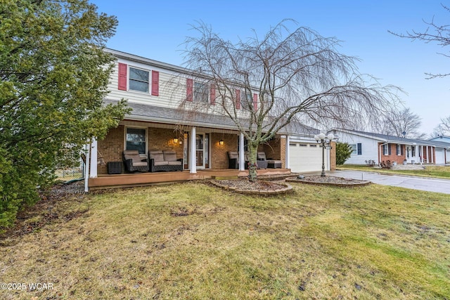 view of front of home featuring a garage, a front lawn, and covered porch