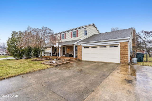 view of front property with a garage, covered porch, and a front lawn