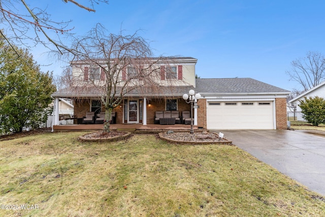 view of property with a garage, a front yard, and covered porch