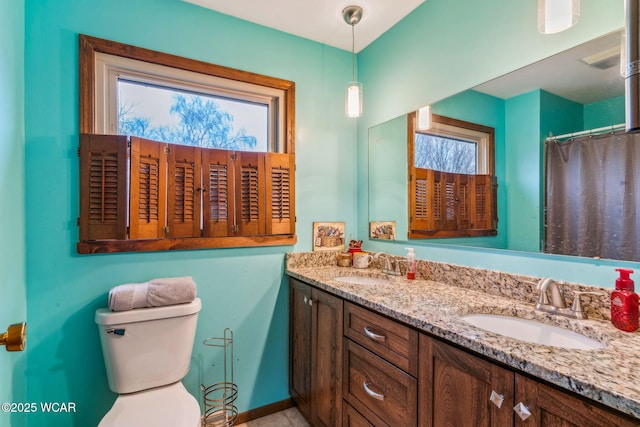 bathroom featuring vanity, a healthy amount of sunlight, and toilet