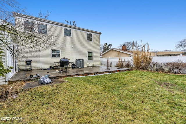 rear view of house featuring a wooden deck, a yard, and cooling unit