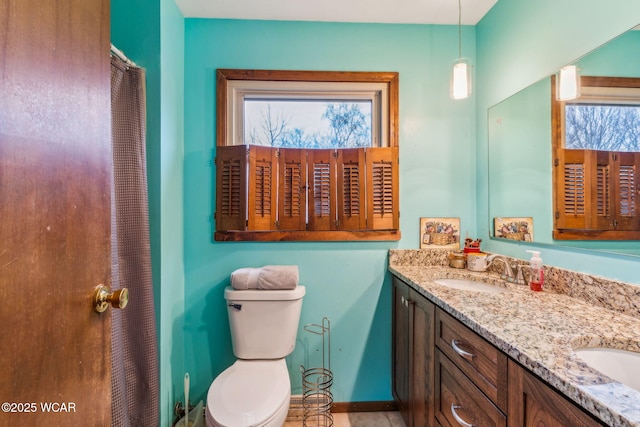 bathroom featuring vanity, plenty of natural light, and toilet