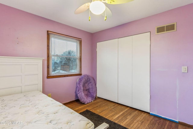 bedroom featuring ceiling fan, dark hardwood / wood-style floors, and a closet